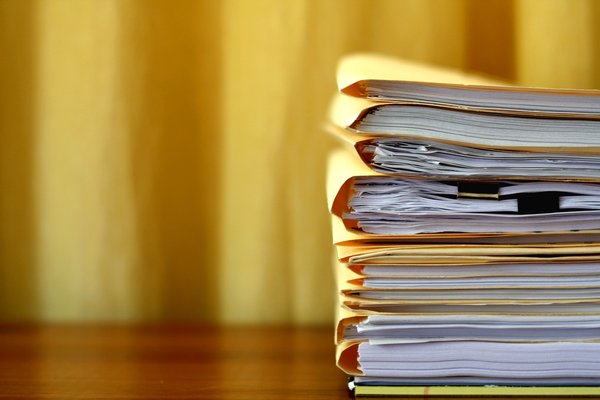A stack of manila folders full of documents.
