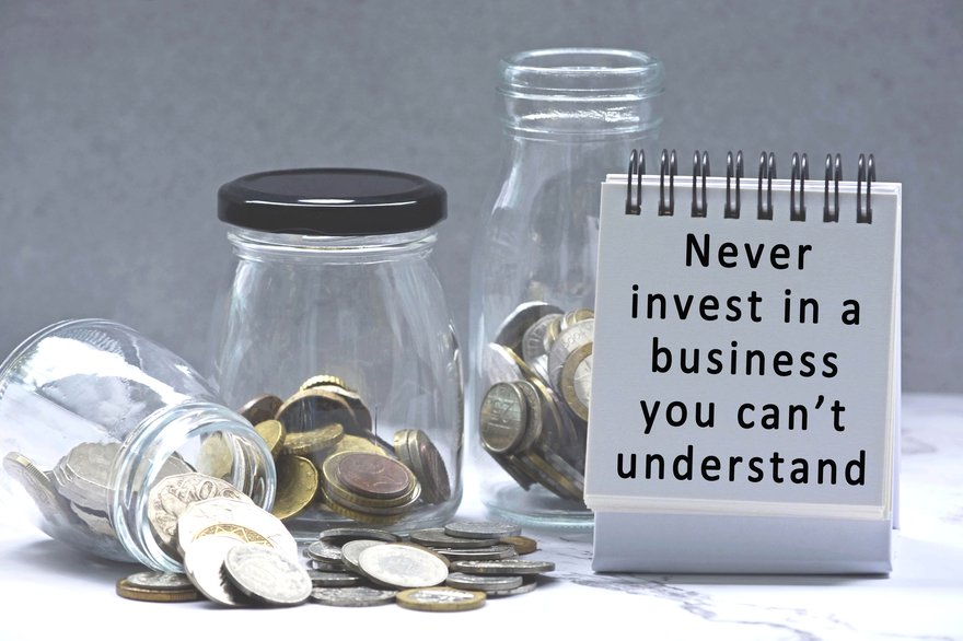 Sign warning you not to invest in things you don't understand, with jars of coins spilling around it.