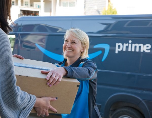 Amazon delivery worker hands a box to a customer.