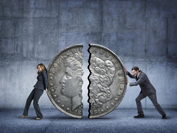 Woman and man pushing a coin split in half back together