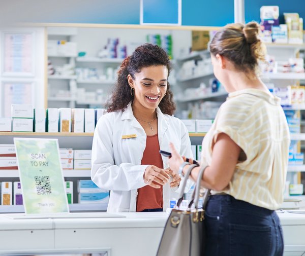 Adult pays for medication in pharmacy.