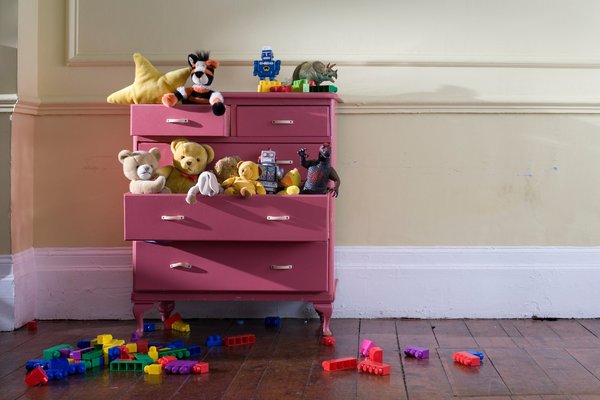 A dresser overflowing with toys.