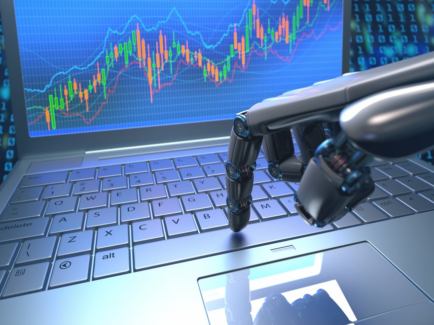 A robot's hand pressing a key on laptop that has rising stock charts on its screen.