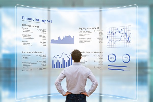 Person standing in front of virtual screen with a financial report on it.