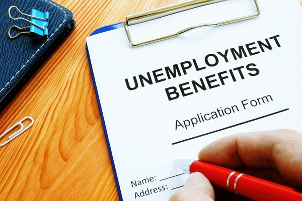Person filling out unemployment benefits application form