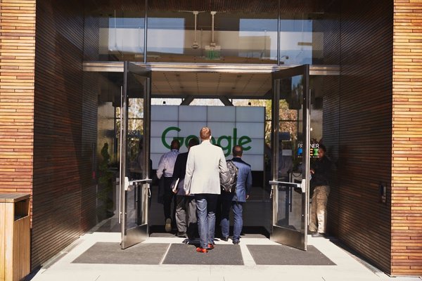 Executives walking into Google's headquarters entrance.