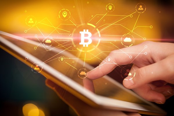 Close-up of finger tapping tablet with Bitcoin imagery representing global connectivity.