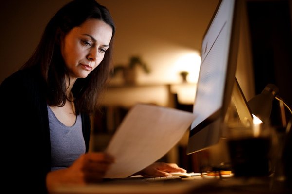 Woman researching self-directed IRA providers at home at night.