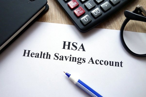 Piece of paper labeled HSA with calculator and pen sitting on it.