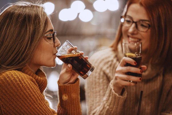 Two people enjoying glasses of cola.