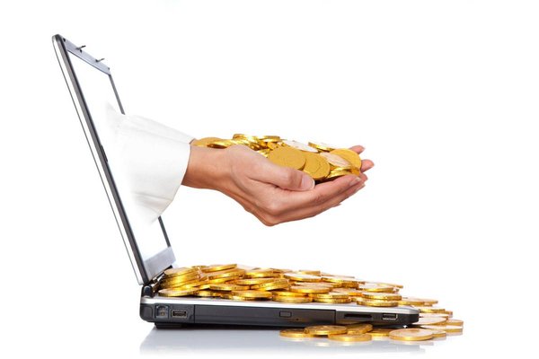 Laptop with gold coins to show accounting profit from software development.