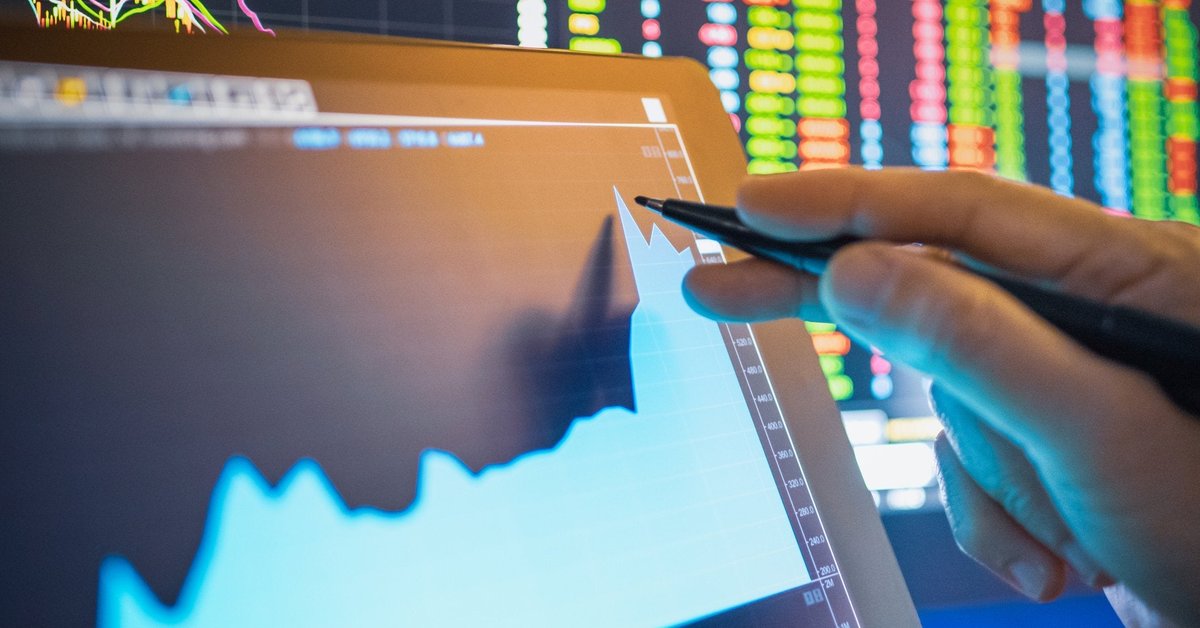 Person using pen to point to rising graph of computer screen.