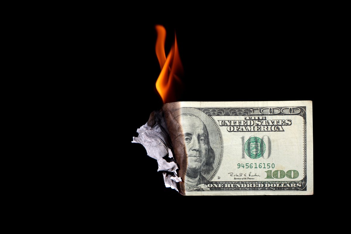 100 dollar bill burning -- wasting money cash