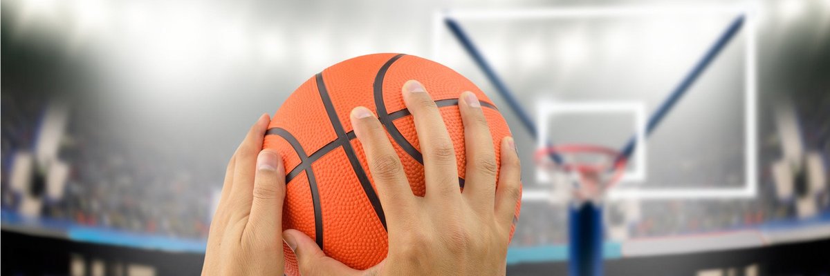 Man holding basketball in hands aiming for hoop.