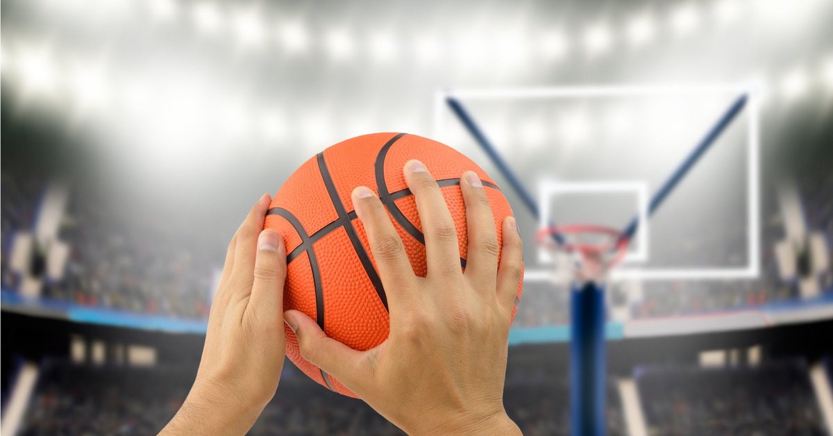 Man holding basketball in hands aiming for hoop.