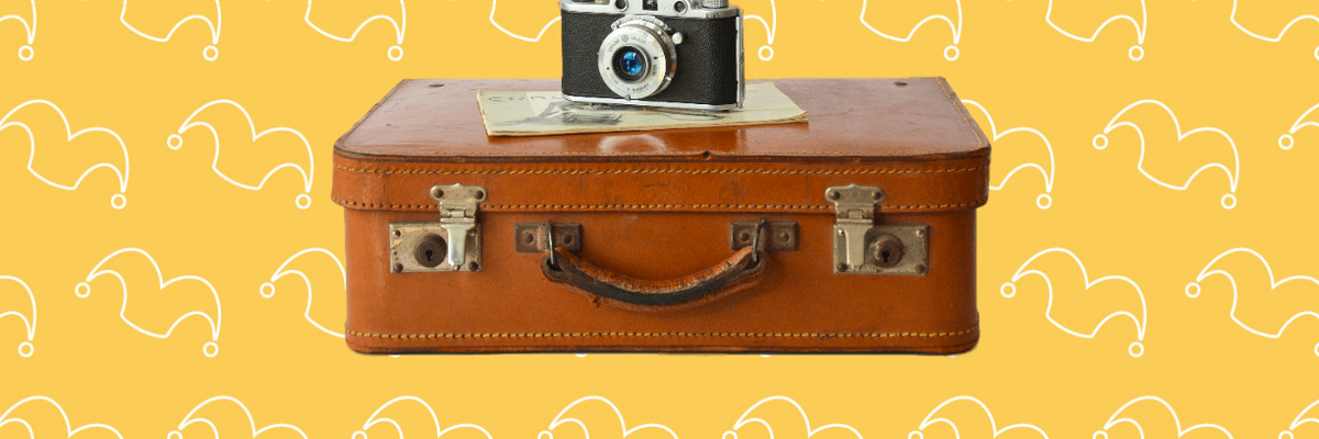 An old leather suitcase with a camera on top of it