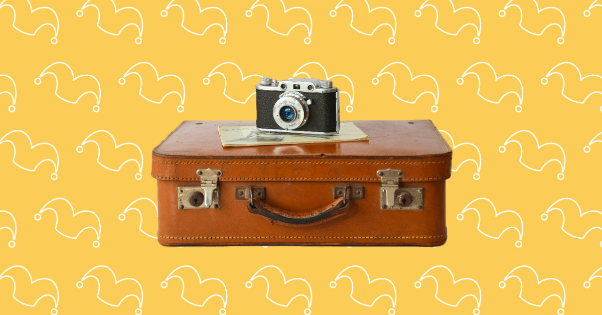 An old leather suitcase with a camera on top of it