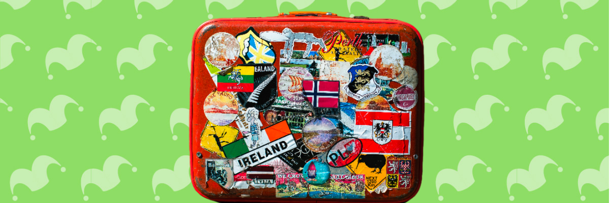 A suitcase covered in stickers against a green background
