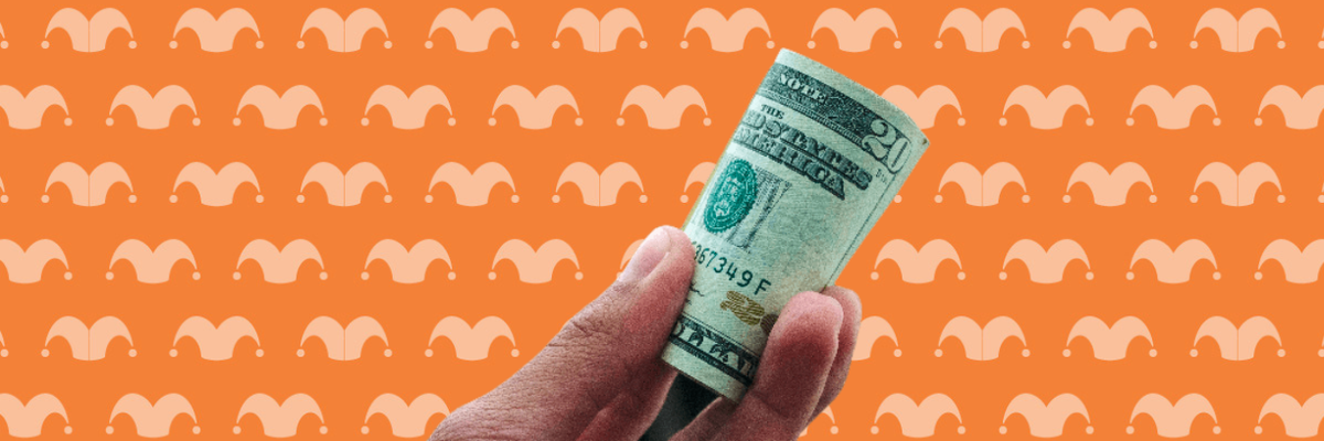 A hand holding a rolled up wad of bills