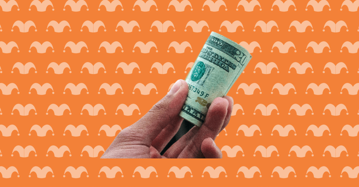 A hand holding a rolled up wad of bills