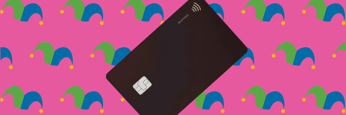 A black credit card against a pink background