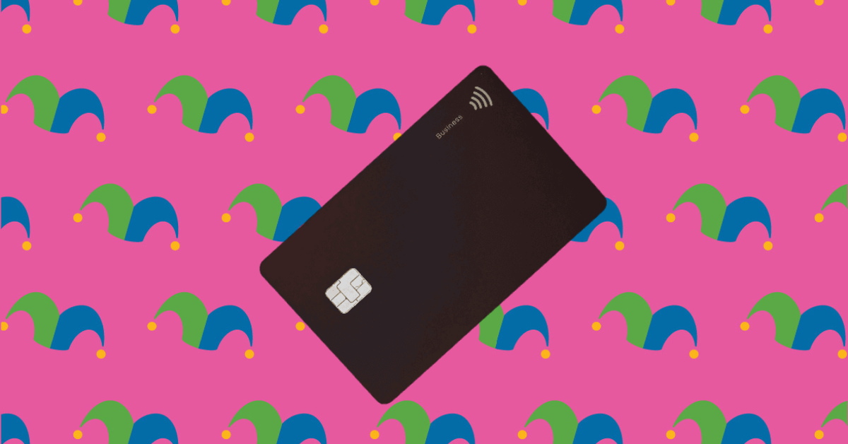 A black credit card against a pink background