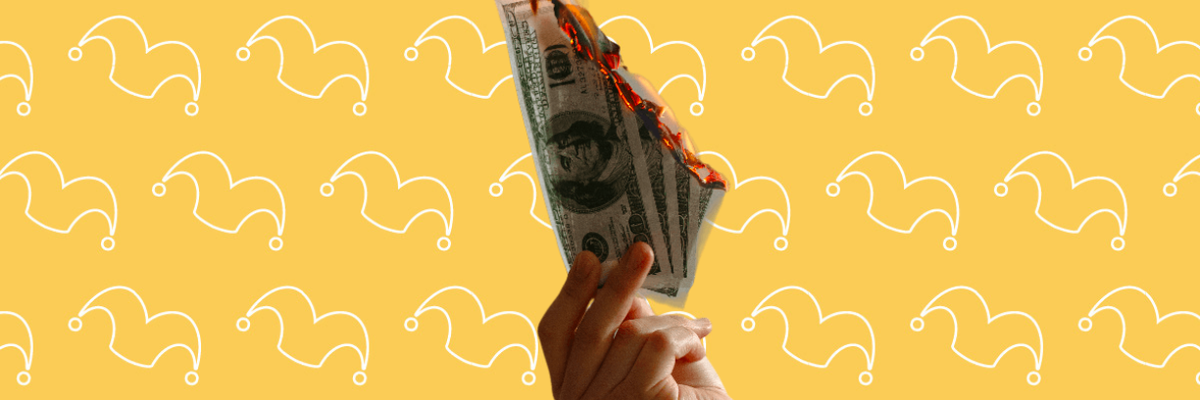 A hand holding four hundred dollar bills that are on fire