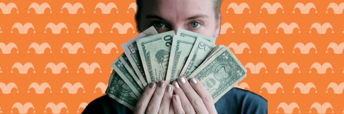 A person holding a bunch of dollar bills in front of their face