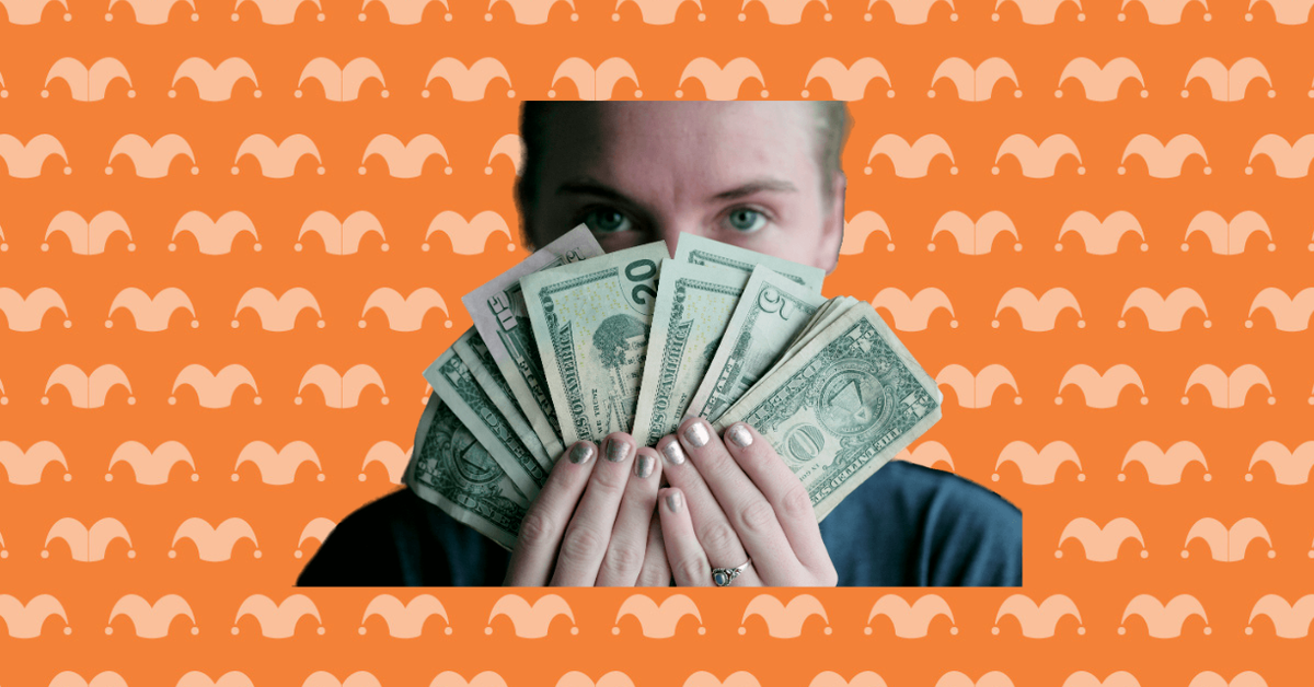 A person holding a bunch of dollar bills in front of their face