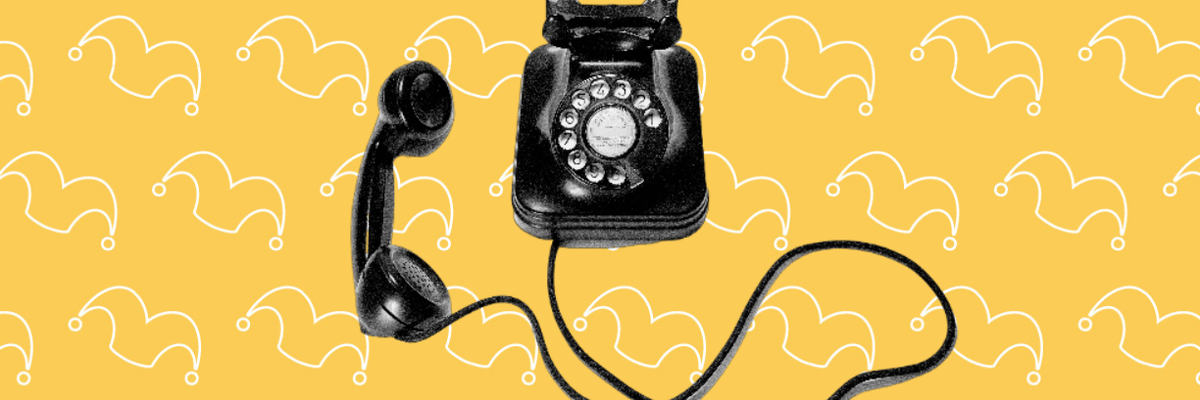 An old black rotary phone against a yellow background