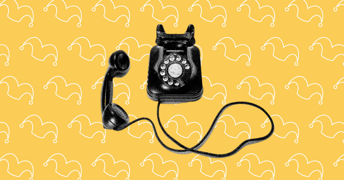 An old black rotary phone against a yellow background