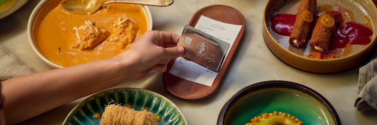 Amex Platinum mirror card design paying for restaurant meal.