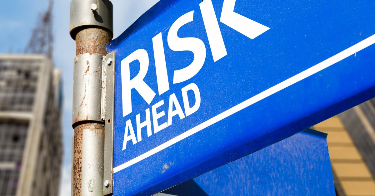 A blue street sign reading Risk Ahead.
