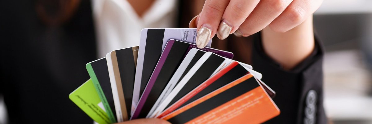 A person holding a fan of credit cards.