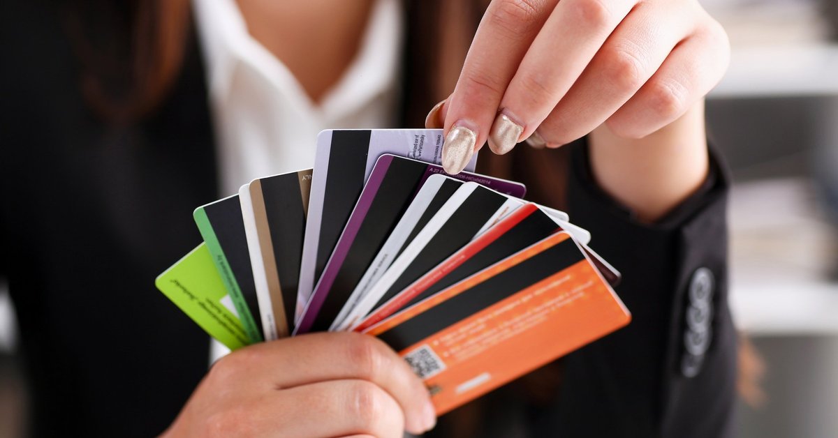 A person holding a fan of credit cards.
