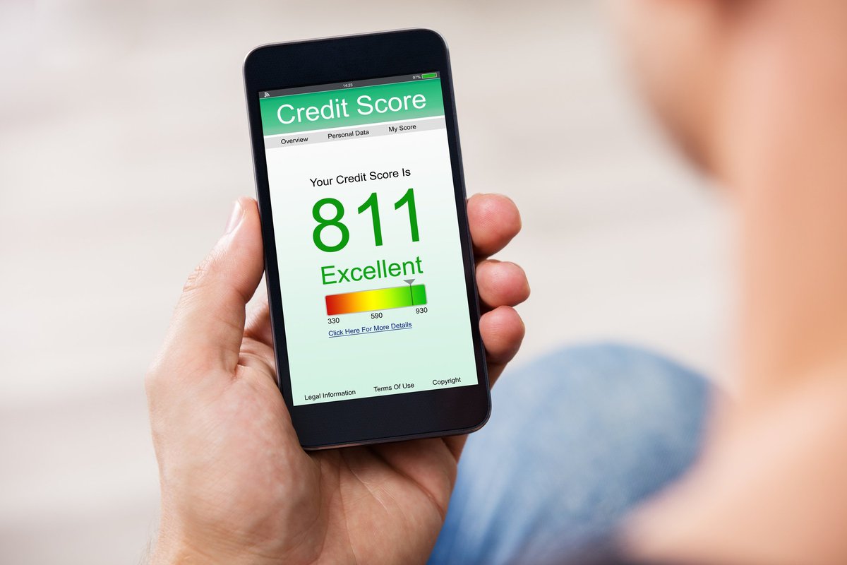 A person holding a smartphone that says 811 credit score.