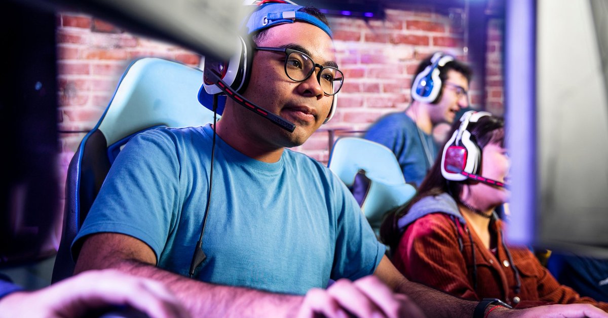 Adults engaging in computer gaming in a room together.