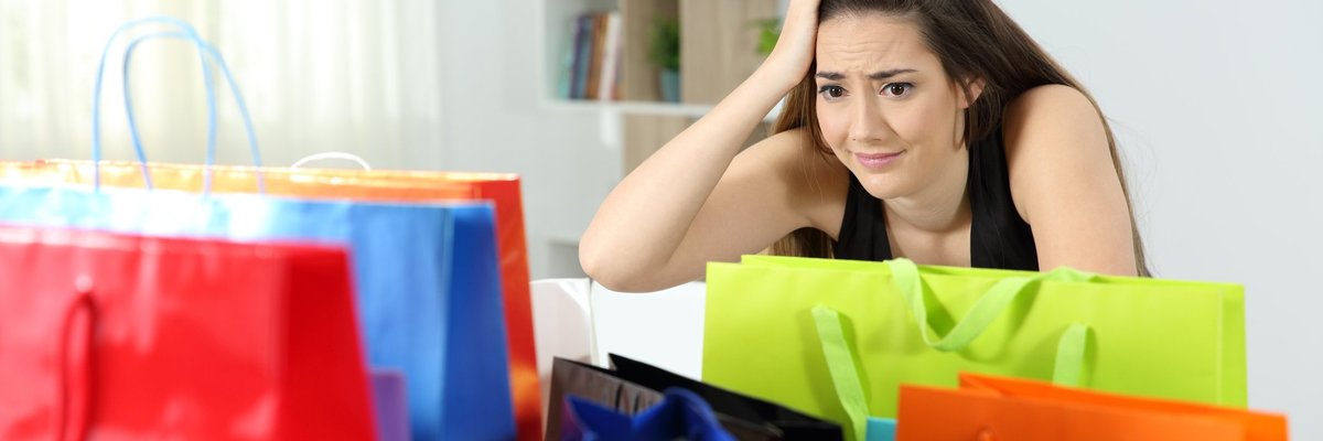 Woman in her home and freaking out as she looks at a bunch of shopping bags.
