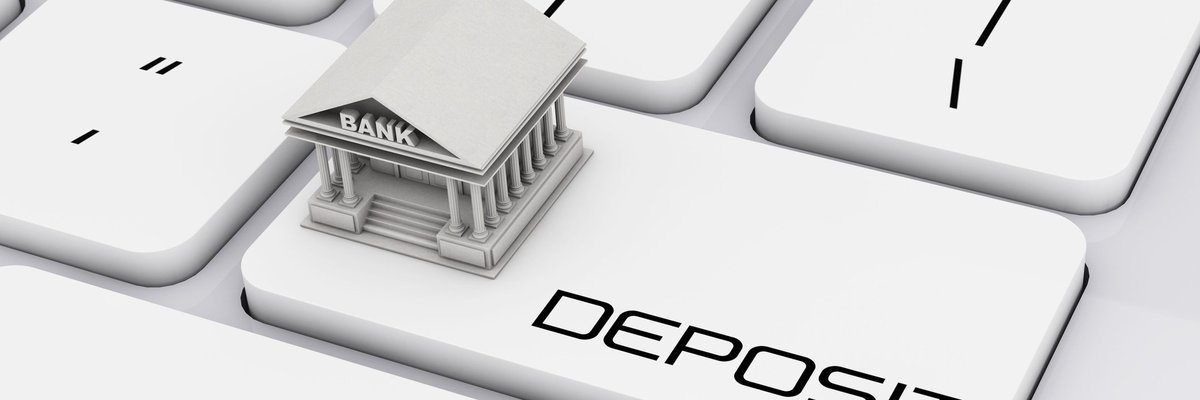 Keyboard with Deposit button and a bank on top of it.
