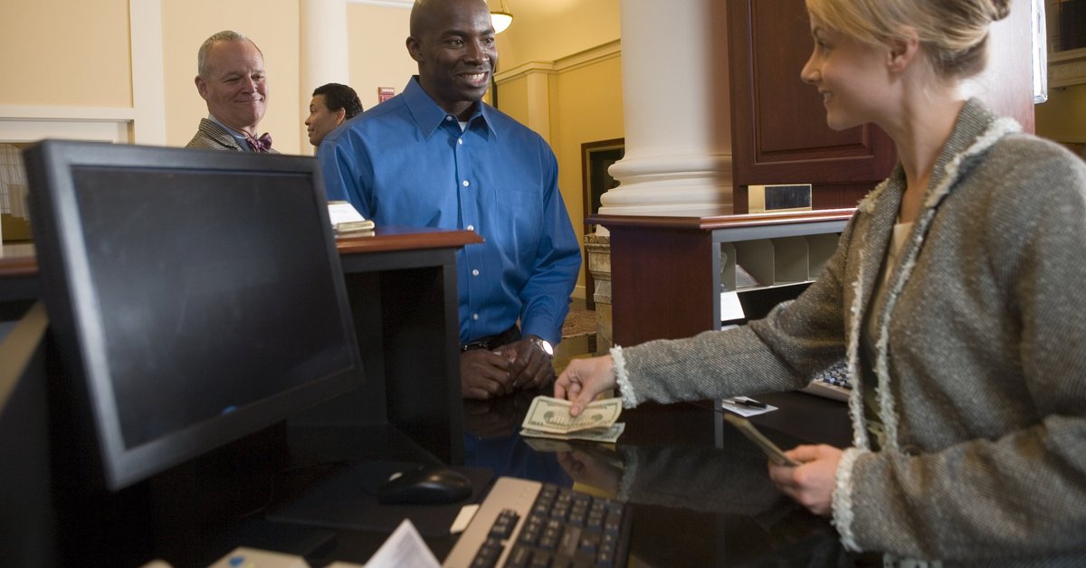 Bank teller assisting a customer with cash transaction.