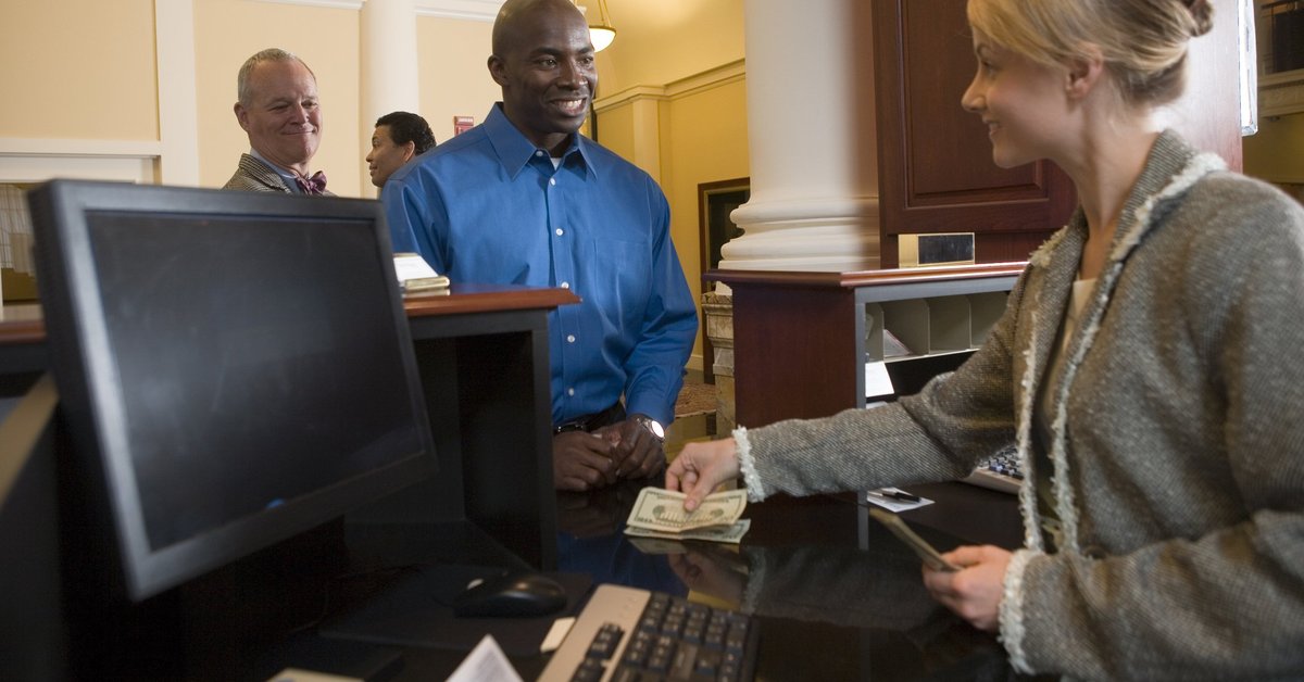 Bank teller assisting a customer with cash transaction.
