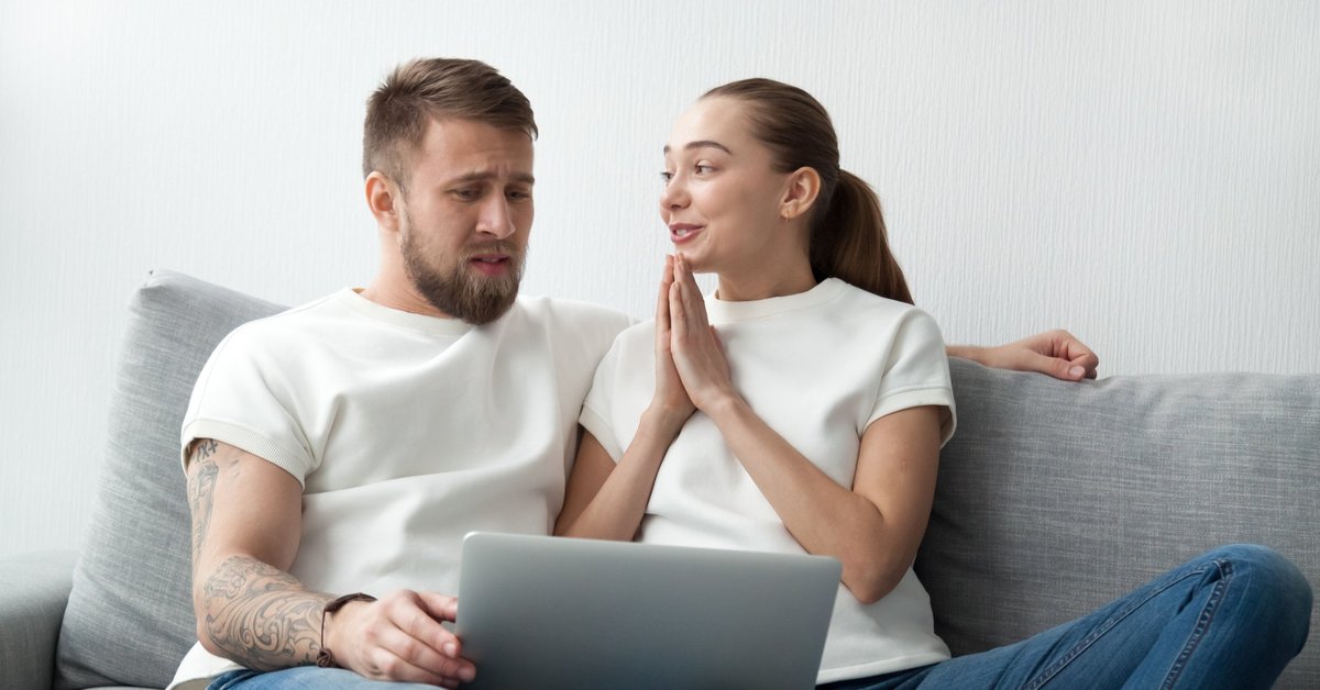 Woman Holding Hands Up In A Prayer Motion To Her Skeptical Boyfriend