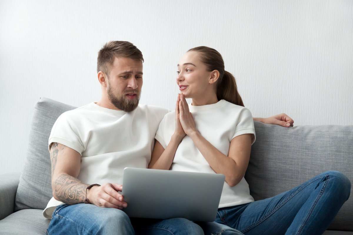 Woman Holding Hands Up In A Prayer Motion To Her Skeptical Boyfriend