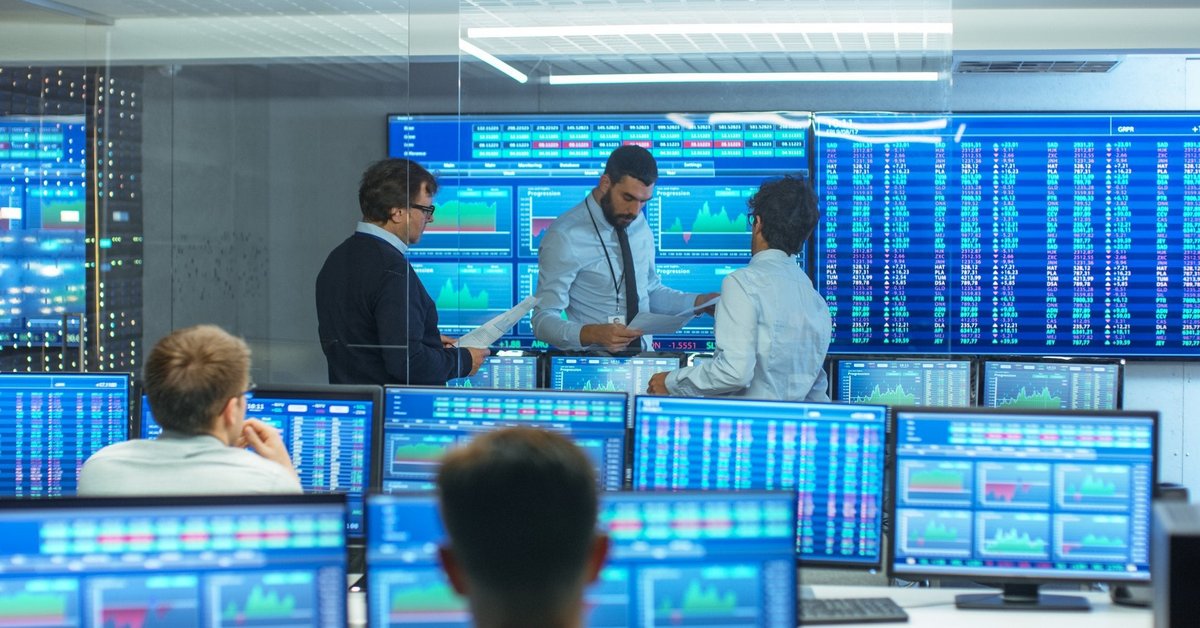 People review data in a room filled with computer screens