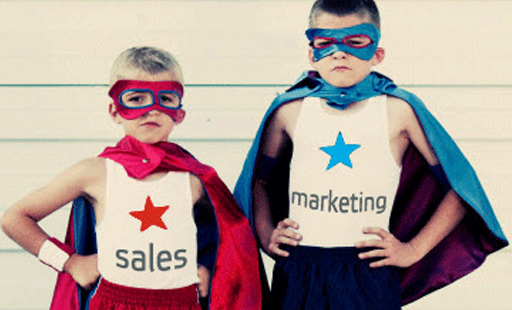 Two children dressed up in superhero costumes labeled sales and marketing