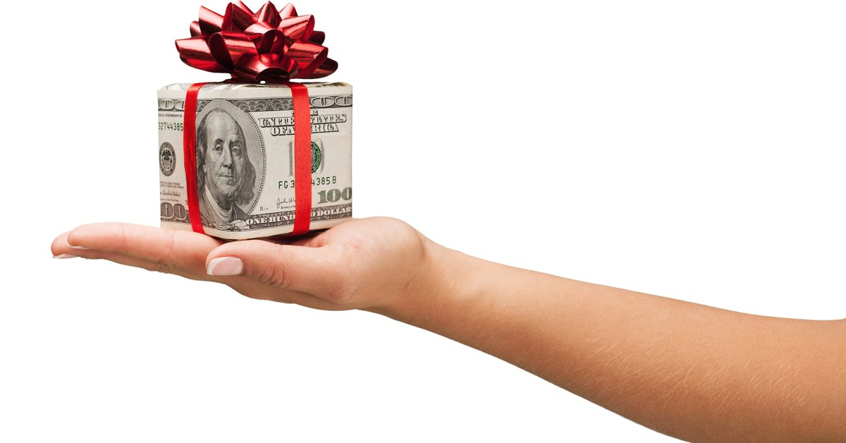 A hand holds a gift-wrapped box.