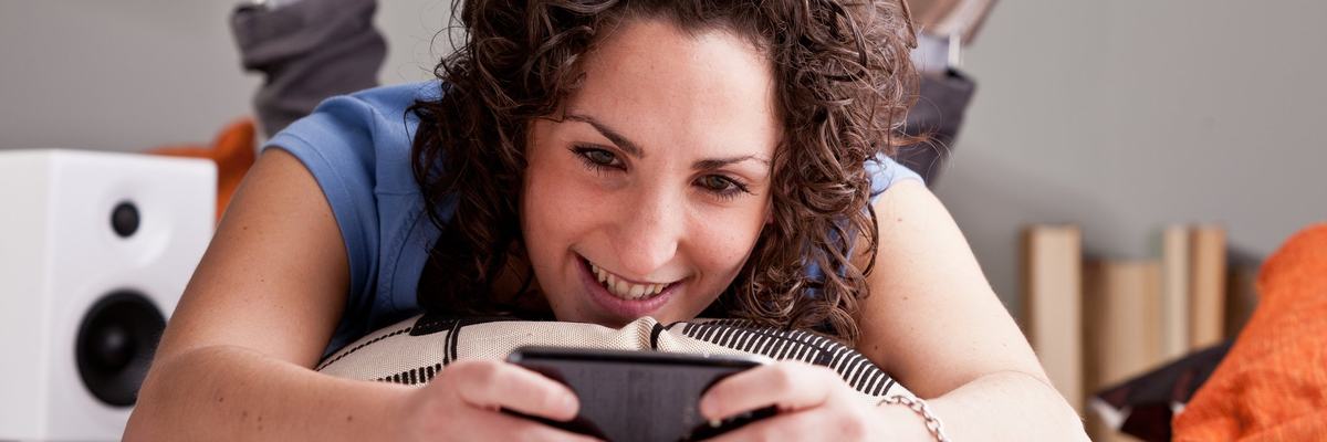 Woman laying on the floor using her cell phone.