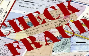 The words “CHECK FRAUD” in red letters stamped on top of a pile of checks.