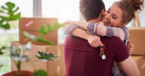 Couple Hugging With Keys To New House.jpg