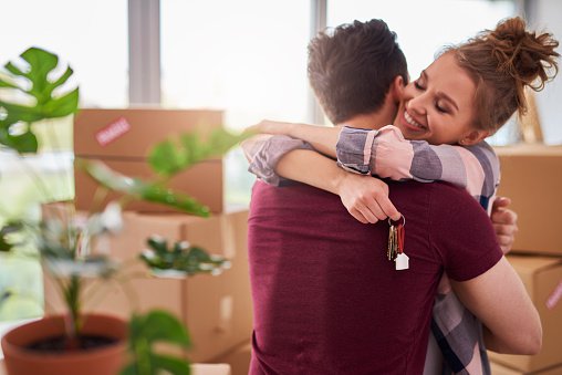 Couple Hugging With Keys To New House.jpg